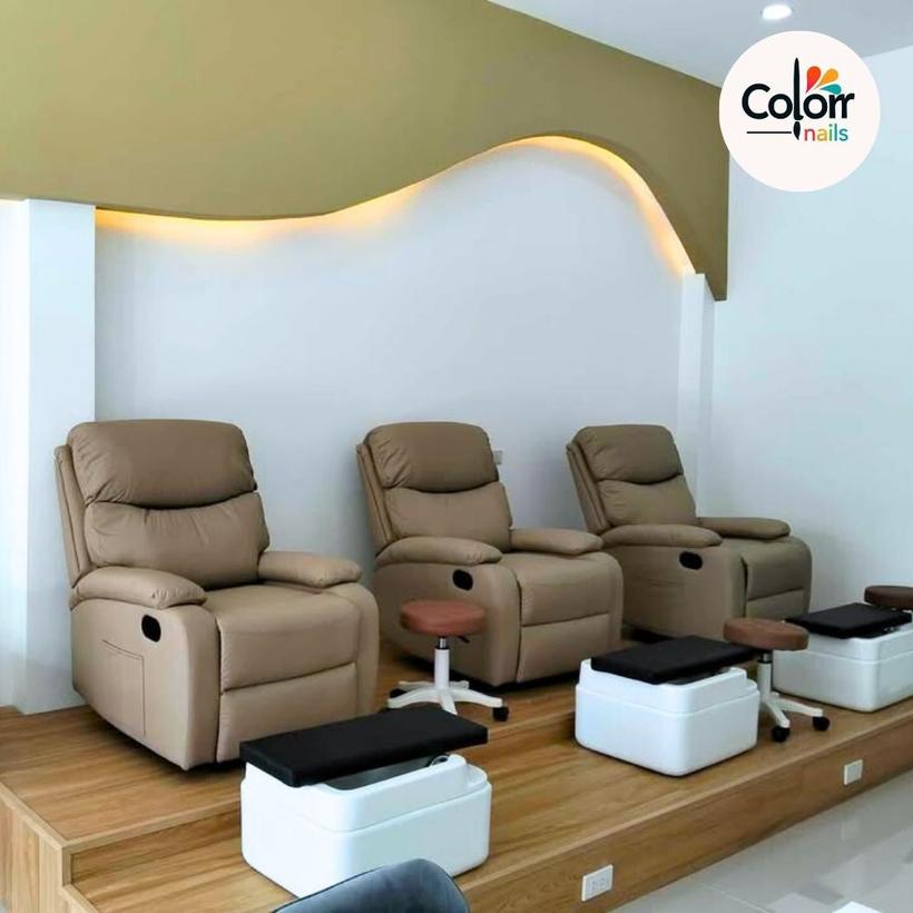 Row of pedicure recliner chairs on a wooden platform