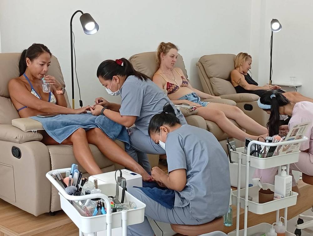 Guests relaxing in pedicure chairs while technicians work at Colorr Nails, Koh Phangan